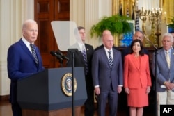 President Joe Biden, left, speaks about an executive order in the East Room at the White House in Washington, Tuesday, June 4, 2024. (AP Photo/Alex Brandon)