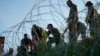 Para migran berusaha menerobos kawat berduri di sepanjang tepi sungai Rio Grande setelah menyeberang dari Meksiko ke perbatasan AS, di kota Eagle Pass, Texas, 1 Agustus 2023 lalu. 