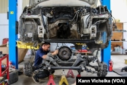 ជាងកំពុង​ជួសជុល​រថយន្ត​ក្នុង​យានដ្ឋាន​មួយ​ នៅ​រាជធានី​ភ្នំពេញ កាលពី​ថ្ងៃទី​២៩ ខែមករា ឆ្នាំ​២០២៣។ (កាន់ វិច្ឆិកា/វីអូអេ)