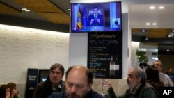 Customers have breakfast in a restaurant while Spanish Prime Minister Pedro Sanchez appears on a television broadcast in Madrid, April 29, 2024. 