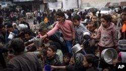 FILE - Palestinians line up for a free meal in Rafah, Gaza Strip, Dec. 21, 2023.