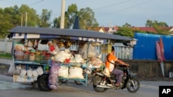 អាជីវករម្នាក់ដឹកទំនិញលក់តាមតូបចល័ត នៅជាយរាជធានីភ្នំពេញ កាលពីថ្ងៃទី ២០ ខែកញ្ញា ឆ្នាំ ២០២៣។ 