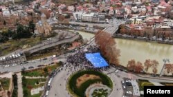 FILE - Participants carry a giant European Union flag during a procession in support of Georgia's membership in the EU in Tbilisi, Dec. 9, 2023. Tbilisi will be the host of an Asian Development Bank annual meeting beginning May 2, 2024.