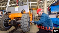 中国山东省青州市的一个铲车工厂的工人在装配铲车。（2023年10月18日）