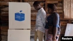 Voters stand by the poll booth at the Nyabushongo Institute polling center on the second day of the Presidential election in Goma, North Kivu province of the Democratic Republic of Congo, Dec. 21, 2023.