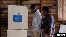 Voters stand by the poll booth at the Nyabushongo Institute polling center on the second day of the Presidential election in Goma, North Kivu province of the Democratic Republic of Congo, Dec. 21, 2023.