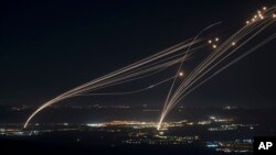 The Israeli Iron Dome air defense system fires profectiles to intercept an attack from Lebanon over the Galilee region as seen from the Israeli-annexed Golan Heights, Aug. 4, 2024. 