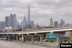 Mobil-mobil terjebak banjir akibat hujan lebat, dengan latar belakang menara Burj Khalifa di Dubai, Uni Emirat Arab, 17 April 2024. REUTERS/Amr Alfiky