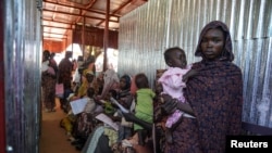 FILE - A woman and baby wait in line at the Zamzam displacement camp, close to El Fasher in North Darfur, Sudan, in January 2024. The United Nations on April 26, 2024, is warning of renewed and escalating violence in the area. (MSF/Mohamed Zakaria/Handout via Reuters)