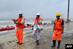 Volunteers of the Cyclone Preparedness Programm (CPP) use a megaphone, asking people to evacuate as a preventive measure in Kuakata, Bangladesh, on May 26, 2024, ahead of cyclone Remal's landfall.