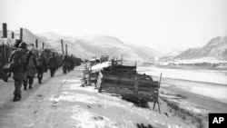 FILE - Americans soldiers march along the North Korean bank of the Yalu River, Nov. 25, 1950. (AP Photo/Gene Herrick)