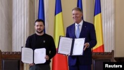 Ukrainian President Volodymyr Zelenskyy poses with Romania's President Klaus Iohannis following signing a strategic partnership in Bucharest, Romania, Oct. 10, 2023. (Inquam Photos/Octav Ganea via Reuters)