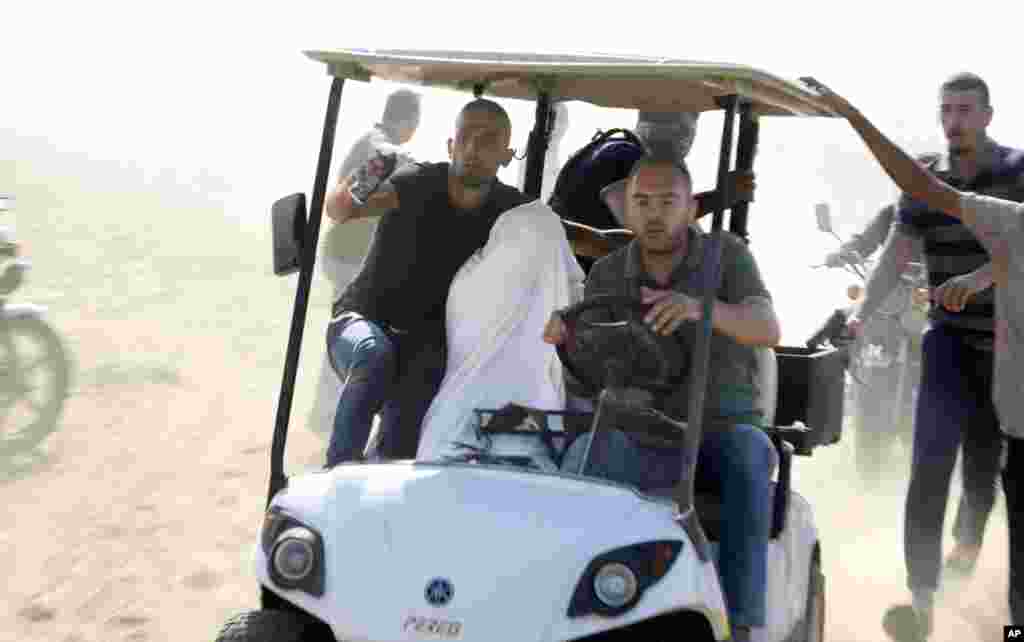 Palestinians transport a captured Israeli civilian from Kibbutz Kfar Azza into the Gaza Strip, Oct. 7, 2023. 