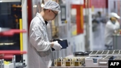 FILE - A worker produces solar photovoltaic modules used for solar panels at a factory in Suqian in China's eastern Jiangsu province, May 9, 2023.