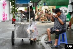 រូបឯកសារ៖ បុរសម្នាក់​កំពុង​បរិភោគ​អាហារ​ពេលព្រឹក​នៅតាម​ដងផ្លូវមួយ​ក្នុងរាជធានីភ្នំពេញ កាលពីថ្ងៃទី២៦ ខែមីនា ឆ្នាំ២០២៤។