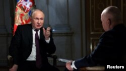 블라디미르 푸틴 러시아 대통령이 12일 모스크바에서 드미트리 키셀료프(뒷모습) 로씨야 세고드냐 미디어그룹 대표와 인터뷰하고 있다.