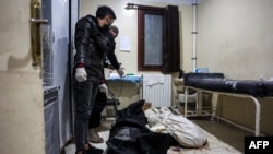 Men stand over the bodies of two victims who were killed in the aftermath of reported bombardment by Syrian government forces, at a hospital in the rebel-held city of Idlib in northwestern Syria, Dec. 30, 2023. 