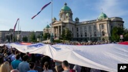 Arhiva - Ljudi drže veliku zastavi Srbije, tokom protesta "Srbija protiv nasilja", ispred Skupštine Srbije, u Beogradu, 3. juna 2023. (Foto: AP/DarkoVojinović)+
