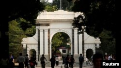 FILE = People walk near the gate of Tsinghua University in Beijing, July 27, 2016. 