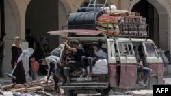 Palestinci koji su pobjegli iz Rafaha u južnom pojasu Gaze istovaruju svoje stvari iz kamiona po dolasku da u Khan Yunis 12. maja 2024.