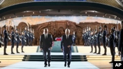 Presiden Rusia Vladimir Putin, kiri, dan Presiden Uzbekistan Shavkat Mirziyoyev mengunjungi taman Yangi O'zbekiston selama kunjungan Putin ke Tashkent, Uzbekistan, Minggu 26 Mei 2024. 