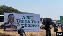 People walk past a ruling Zanu PF poster thanking Zimbabweans for voting for President Emmerson Mnangagwa, in Harare, Sept. 4, 2023. (Columbus Mavhunga/VOA)