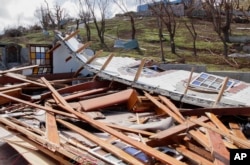 FILE - A man inspects a home destroyed by Hurricane Beryl in Clifton, Union Island, St. Vincent and the Grenadines, July 4, 2024.