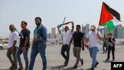 People waving Palestinian flags walk toward the Imam Muhammad bin Abdul Wahhab mosque in Doha, Qatar, on Aug. 2, 2024, for the funeral of Hamas leader Ismail Haniyeh.