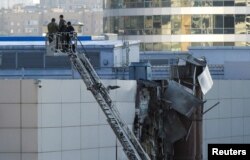 파손된 러시아 모스크바 엑스포센터 시설을 18일 조사 인력들이 살펴보고 있다.