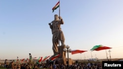 کۆبوونەوەی چەند هاوڵاتییەکی کەرکوک لەبەردەم پەیکەری پێشمەرگە لە 23ی نۆی 2017. پەیکەرەکە بووەتە هێمایەکی شاری کەرکوک و دوای ڕیفراندۆمی سەربەخۆیی هەرێمی کوردستان، لە شوێنی ئاڵای کوردستان ئاڵای عێراق هەڵکرا.