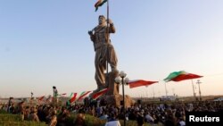 کۆبوونەوەی چەند هاوڵاتییەکی کەرکوک لەبەردەم پەیکەری پێشمەرگە لە 23ی نۆی 2017. پەیکەرەکە بووەتە هێمایەکی شاری کەرکوک و دوای ڕیفراندۆمی سەربەخۆیی هەرێمی کوردستان، لە شوێنی ئاڵای کوردستان ئاڵای عێراق هەڵکرا. 