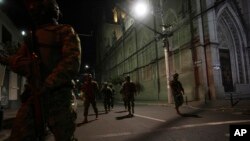 Soldiers walk towards a vehicle that blew up outside the Women´s and Human Rights Ministry building in Quito, Ecuador, Aug. 30, 2023.