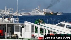 Kapal Garda Pantai China mengerahkan meriam ke arah kapal Unaizah yang disewa oleh militer Filipina untuk membawa pasokan ke beting Second Thomas Shoal di Laut China Selatan, 5 Maret 2024. (Foto: Jam Sta Rosa/AFP)