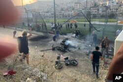 Residents rush to help injured children moments after a rocket attack hit a soccer field in the Druze town of Majdal Shams in the Israeli-controlled Golan Heights, July 27, 2024.