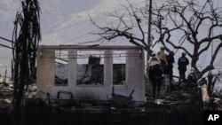 Search-and-rescue team members work in a residential area devastated by a wildfire in Lahaina, Hawaii, Aug. 18, 2023. 