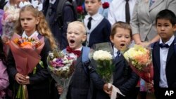First-graders take part in a ceremony marking the start of classes at a school as part of the traditional opening of the school year known as 'Day of Knowledge' in St. Petersburg, Russia, Sept. 1, 2023. 