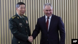 In this photo released by Russian Defense Ministry Press Service, Russian Defense Minister Sergei Shoigu, right, and Chinese Defense Minister Li Shangfu pose for a photo at the International Military Forum Army in Russia, Aug. 15, 2023.