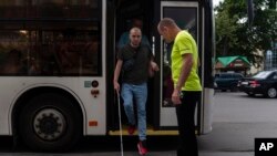 Accompanied by trainer Vasyl Hoshovskyi, Ivan Soroka, a former Ukrainian soldier blinded in the war, gets off a bus in Rivne, Ukraine,