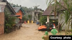 Petugas berusaha mengevakuasi warga yang terjebak banjir dengan perahu karet di Kabupaten Lahat, Sumatera Selatan, Kamis (9/3). (courtesy: BNPB) 