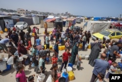 Raseljeni Palestinci čekaju u redu za vodu u kampu zapadno od Deir al-Balaha u Pojasu Gaze, 21. maja 2024. godine.