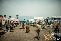 The 42-year-old mother of four who was raped walks in the Bulengo displacement camp, in Congo, Aug. 23, 2023.