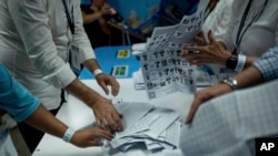 Electoral workers count ballots after the polls closed during general elections in Guatemala City, June 25, 2023.