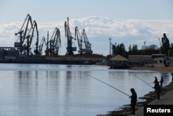 Local residents fish on an embankment, during the course of Russia-Ukraine conflict, in the Azov Sea port of Berdyansk, Zaporizhzhia region, Russian-controlled Ukraine, May 10, 2023.