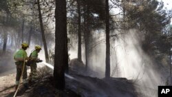 FILE - Firefighters extinguish a forest fire in Fuente la Reina, Castellon de la Plana, Spain, March 29, 2023. 