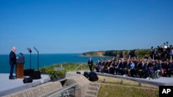 U.S. President Joe Biden speaks about bravery, democracy and D-Day as he stands next to the Pointe du Hoc monument in Normandy, France, June 7, 2024.