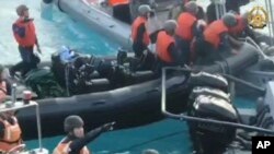 칼을 지닌 중국 해양경비대원들이 남중국해에서 필리핀 보급선에 접근하고 있다. (자료사진)