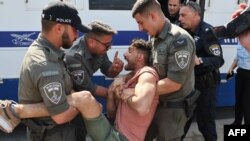 Pasukan kemaman Israel tampak menahan seorang demonstran yang turut serta dalam aksi protes antipemerintah di Tel Aviv pada 1 Maret 2023. (Foto: AFP/Jack Guez)