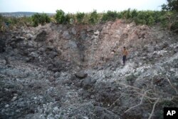 Seorang warga desa Lebanon memeriksa sebuah kawah besar akibat serangan udara Israel, di desa Qalili, Lebanon selatan, Jumat 7 April 2023.