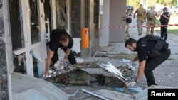 Anggota kepolisian menutup jenazah rekan mereka yang tewas akibat serangan militer Rusia di Kherson, Ukraina, pada 19 September 2023. (Foto: Reuters/Ivan Antypenko)