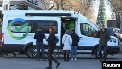 FILE: Para nasabah berbicara dengan pegawai bank di kantor keliling Sberbank di Simferopol, Krimea, 21 Januari 2023. (REUTERS/Alexey Pavlishak)